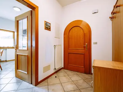 a hallway with a wooden door and a tile floor at Apartment Ardoney-1 by Interhome in Campitello