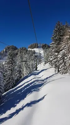 a ski lift going up a snow covered mountain at Piccola Suite sul Civetta in Colle Santa Lucia