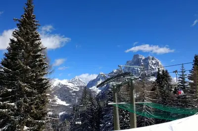a ski lift with a christmas tree and a mountain at Piccola Suite sul Civetta in Colle Santa Lucia