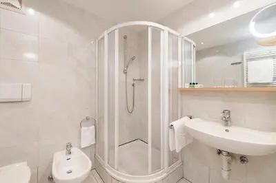 a bathroom with a shower and a toilet and a sink at Residence Hotel Gasser in Bressanone