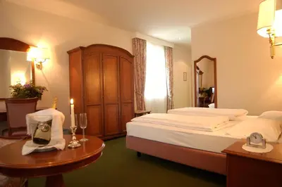 a bedroom with a large bed and a table with a table sidx sidx at Residence Hotel Gasser in Bressanone
