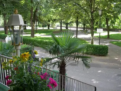 a garden with a fence and flowers and a street light at Residence Hotel Gasser in Bressanone