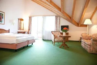 a bedroom with a bed and a table and a chair at Residence Hotel Gasser in Bressanone