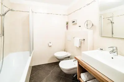 a bathroom with a toilet and a sink and a shower at Almhof Hotel Call in San Vigilio Di Marebbe