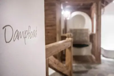 a bunch of wine bottles on shelves on a wall at Landhaus Freiburgerhof in Rifiano