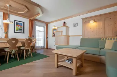 a living room with a couch and a table and chairs at Casa Rododendro - Cavalese Dolomites in Cavalese