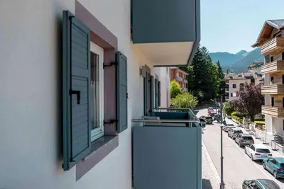 a building with a window and a street with cars at Casa Rododendro - Cavalese Dolomites in Cavalese