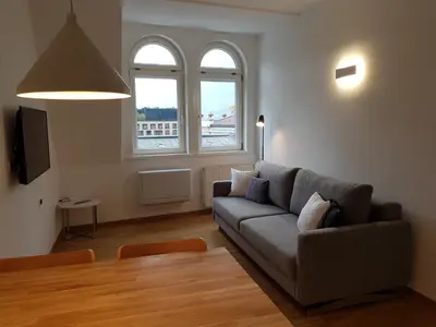 a living room with a couch and two windows at Hager Apartment 3 in Merano
