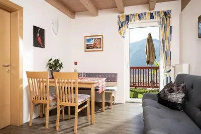 a living room with a table and chairs and a couch at Haus Sauvignon in Cortaccia