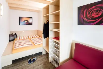 a small bedroom with a bed and a closet at Haus Sauvignon in Cortaccia