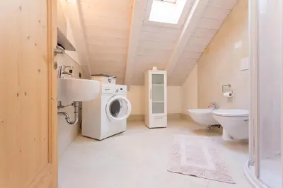 a bathroom with a washing machine and a toilet at Tobià el Salvan in Pera