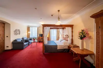 a hotel room with a bed and a couch at Hotel Relais Orsingher in Fiera di Primiero