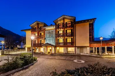 a group of buildings with mountains in the background at Hotel Relais Orsingher in Fiera di Primiero