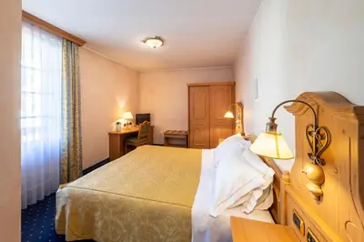 a hotel room with a bed and a lamp at Hotel Relais Orsingher in Fiera di Primiero