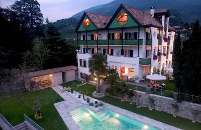 an aerial view of a house with a swimming pool at Hotel Pension Verdorfer in Merano