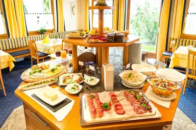 a table with a buffet of food in a restaurant at Hotel Pension Verdorfer in Merano