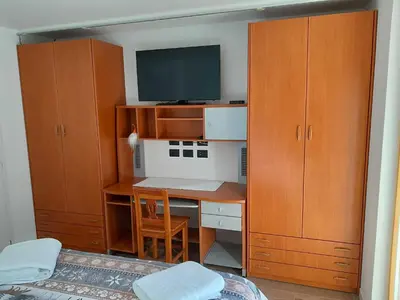 a room with a desk with a tv and wooden cabinets at Paragole in Pera