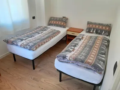 two twin beds in a room with wooden floors at Paragole in Pera