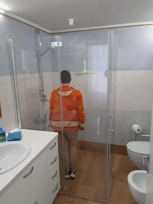 a person standing in a bathroom with a shower at Paragole in Pera