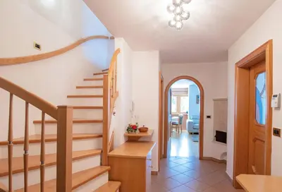 a staircase in a home with white walls and wooden floors at Mountain Living Apartment Idylia in Ortisei
