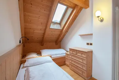 a small bedroom with two beds and a window at Mountain Living Apartment Idylia in Ortisei