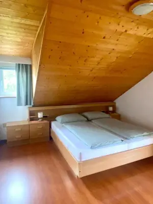 a bed in a room with a wooden ceiling at Schönhuberhof Apartment Panoramablick in Brunico