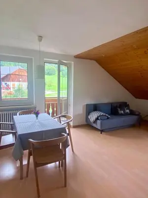 a living room with a blue table and a couch at Schönhuberhof Apartment Panoramablick in Brunico