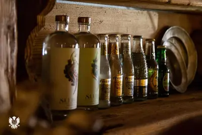 a row of bottles of beer sitting on a shelf at Hotel Astoria in Fiera di Primiero