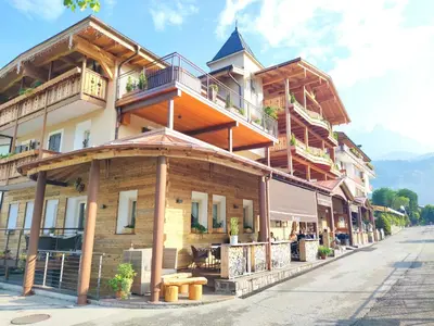 a large wooden building with balconies on a street at Hotel Astoria in Fiera di Primiero