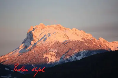 a snow covered mountain with trees in front of it at Dolomiten View - South Tyrol in Villandro