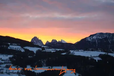 a sunset in the mountains with snow and trees at Dolomiten View - South Tyrol in Villandro