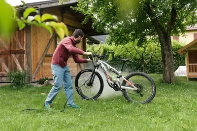 a man is pushing a bike in the grass at Dolomitihouse AUNER in Fiera di Primiero