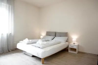 a white bed with two white pillows on it at Bright studio apartment with free private parking in Merano