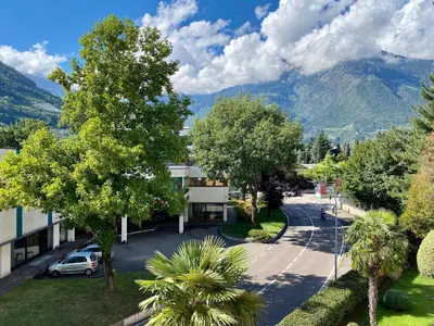 a street in a town with mountains in the background at Bright studio apartment with free private parking in Merano