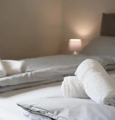 a bed with a pile of white towels on it at Bright studio apartment with free private parking in Merano