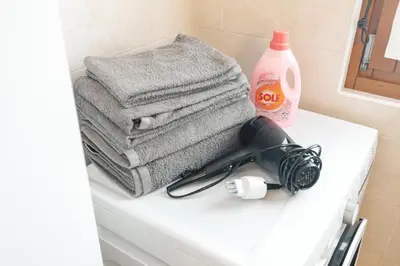 a bathroom counter with towels and a hair dryer on it at Dolomitihouse AVET in Fiera di Primiero