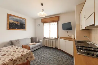 a small living room with a couch and a kitchen at Dolomitihouse AVET in Fiera di Primiero