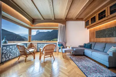 a living room with a couch and chairs and a balcony at Apartment Murata in Ortisei