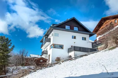 a house on top of a snow covered hill at Apartment Murata in Ortisei