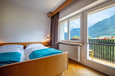 a bedroom with a bed and a large window at Apartment Murata in Ortisei
