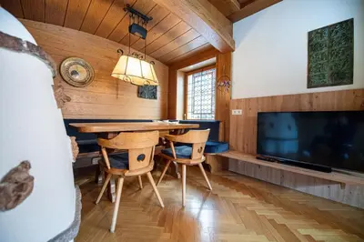 a dining room with a table and chairs and a tv at Apartment Murata in Ortisei