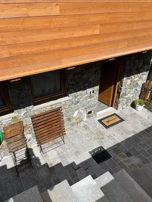a building with two benches in front of it at Remina Dolomiti house in Tonadico