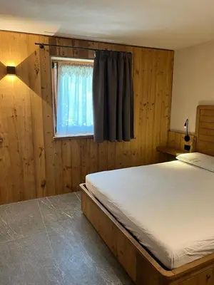 a bedroom with a bed and a window at Remina Dolomiti house in Tonadico