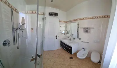 a bathroom with a shower and a sink and a toilet at Schlernwohnung in Seis am Schlern in Siusi