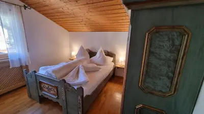a bedroom with a bed with white pillows and a mirror at Schlernwohnung in Seis am Schlern in Siusi
