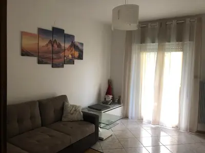 a living room with a couch and a window at Casa di Max - private room in apartment with shared bathroom FREE PARKING in Bolzano