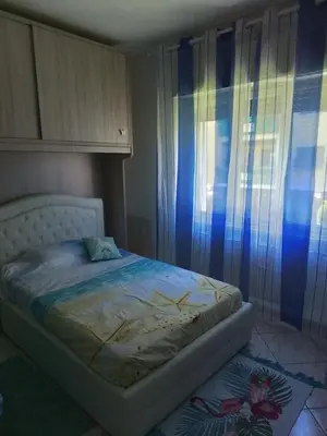 a bedroom with a bed with blue curtains at Casa di Max - private room in apartment with shared bathroom FREE PARKING in Bolzano