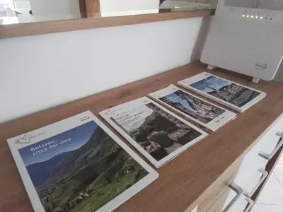 a table with brochures on top of it at Casa di Max - private room in apartment with shared bathroom FREE PARKING in Bolzano