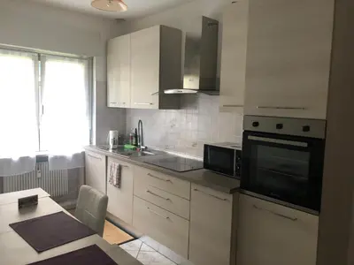 a kitchen with white cabinets and a black microwave at Casa di Max - private room in apartment with shared bathroom FREE PARKING in Bolzano
