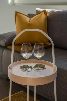 two wine glasses on a table in front of a couch at Pia´s Bleibe in Caldaro